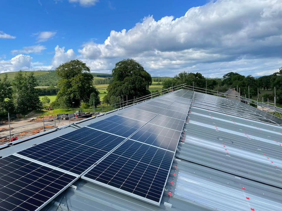 A close-up of solar panels installed on a large farm shed roof in Dumfries & Galloway
